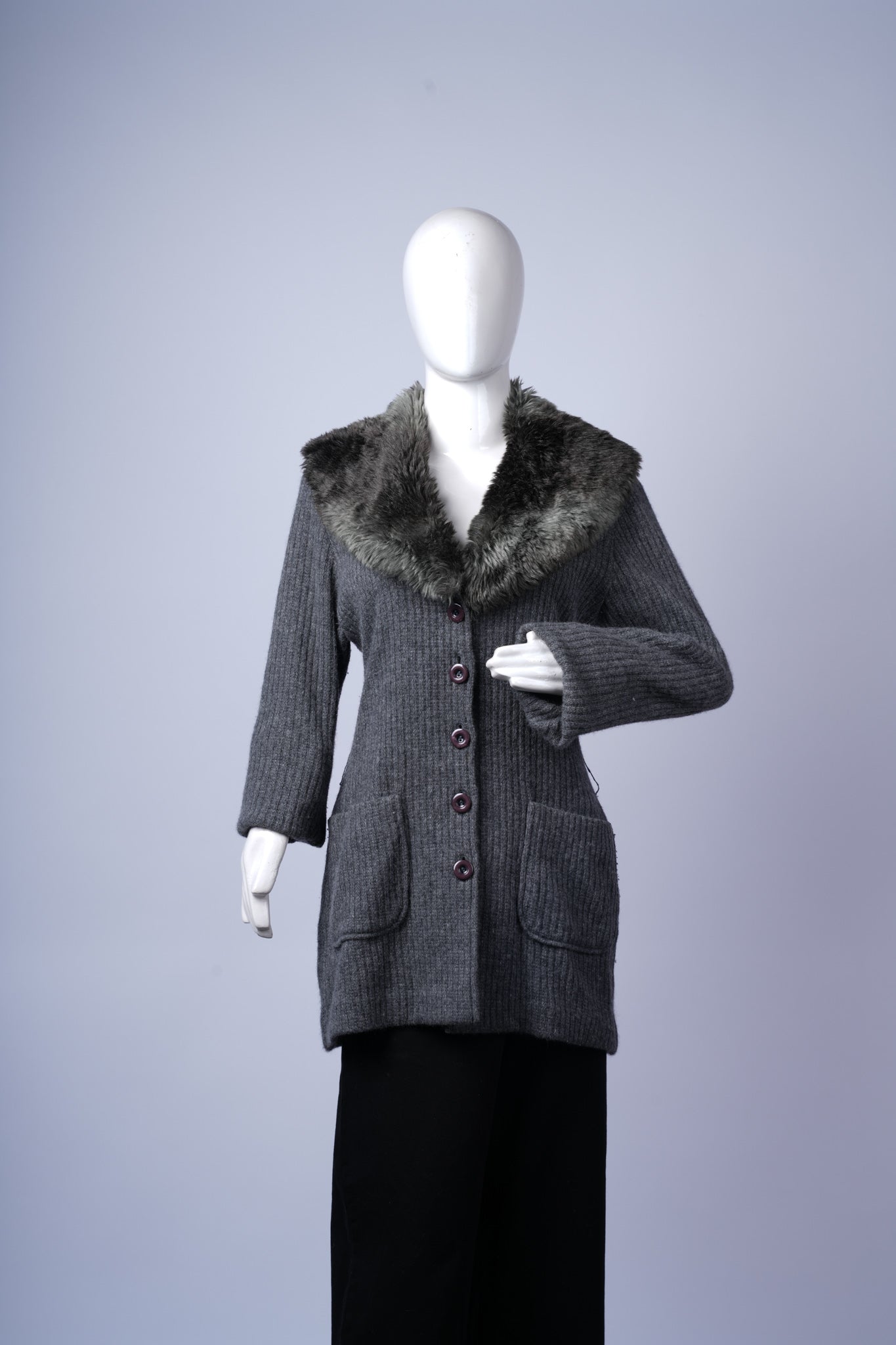 women's cozy knit cardigan featuring extended length and textured fur trim.
