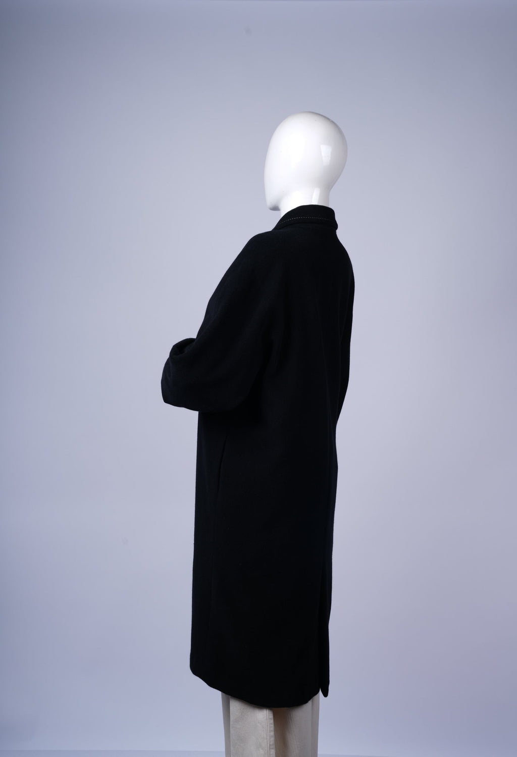 Tailored black coat with sleek silhouette and versatile styling options.