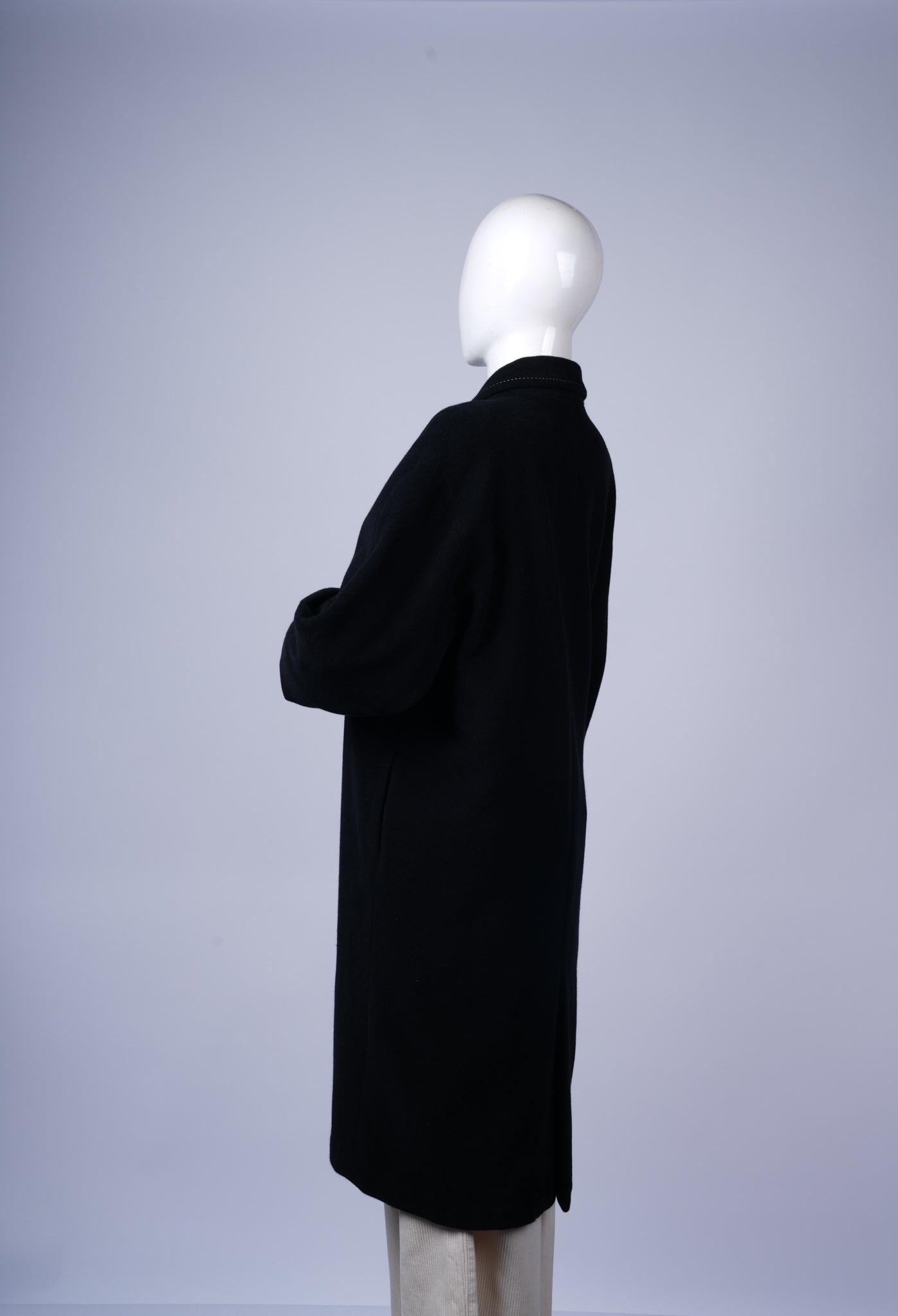 Tailored black coat with sleek silhouette and versatile styling options.