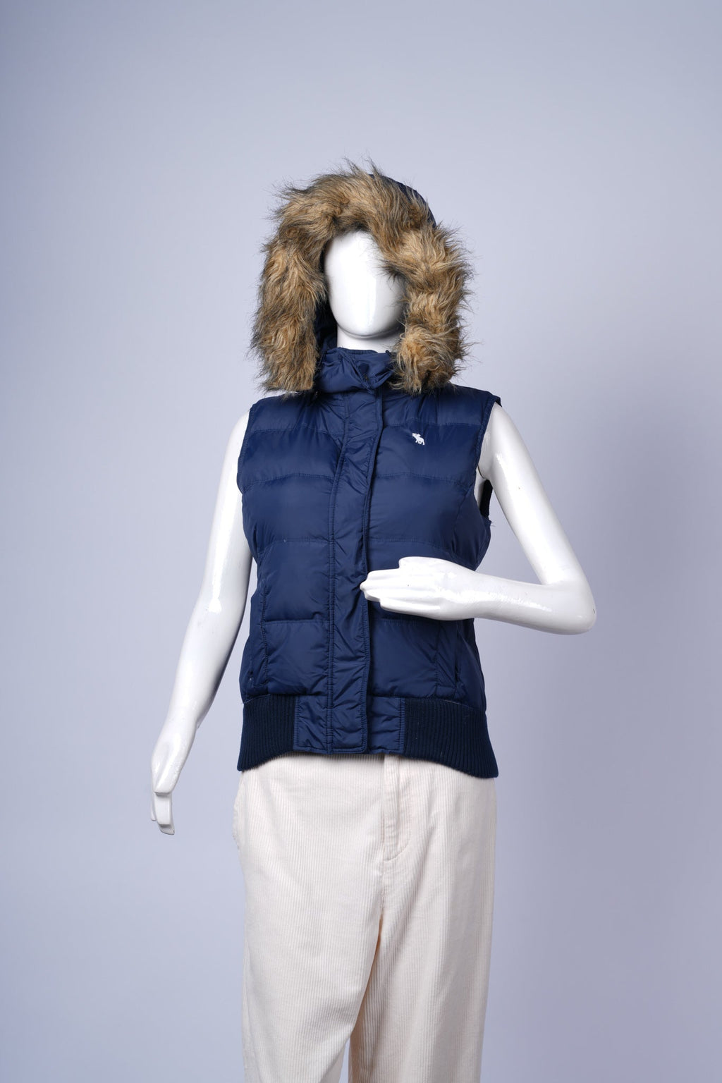 Stylish navy puffer vest for women with side pockets and brand detailing.