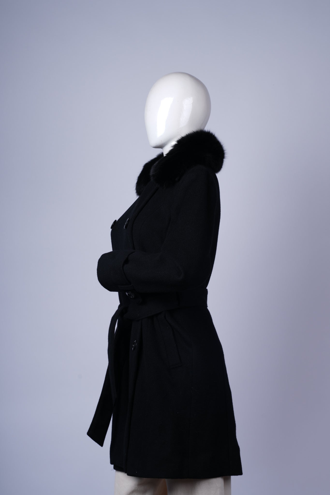 Sophisticated long coat with fur trim and cinched waist for polished cold-weather looks.