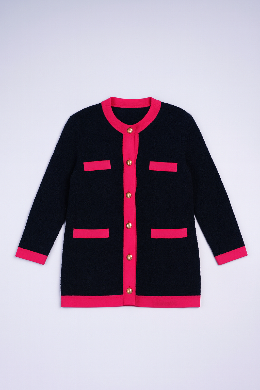 Navy bouclé knit cardigan with red trim, gold buttons, and patch pockets.