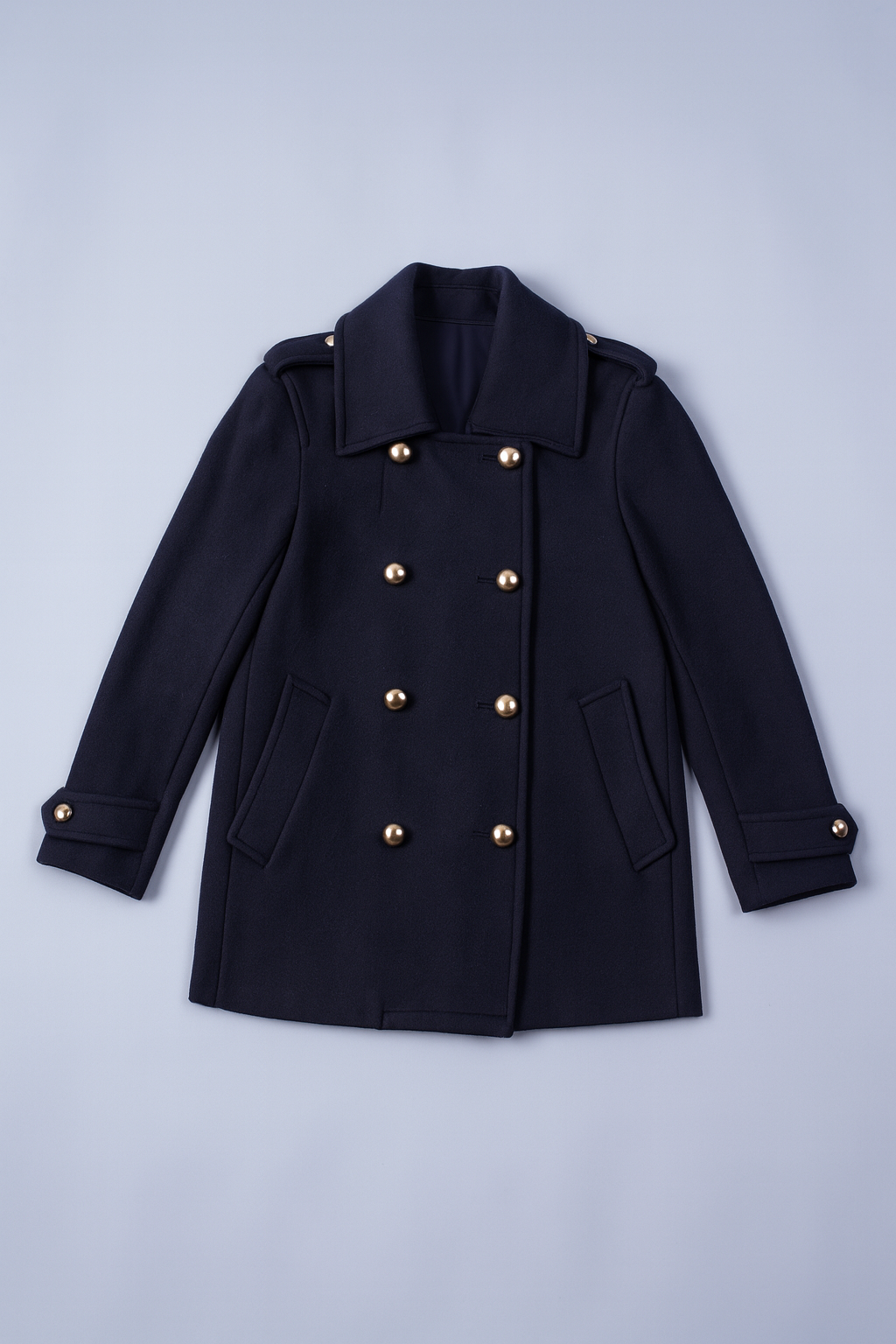 Dark blue pea coat with wide lapels, gold buttons, and side pockets.