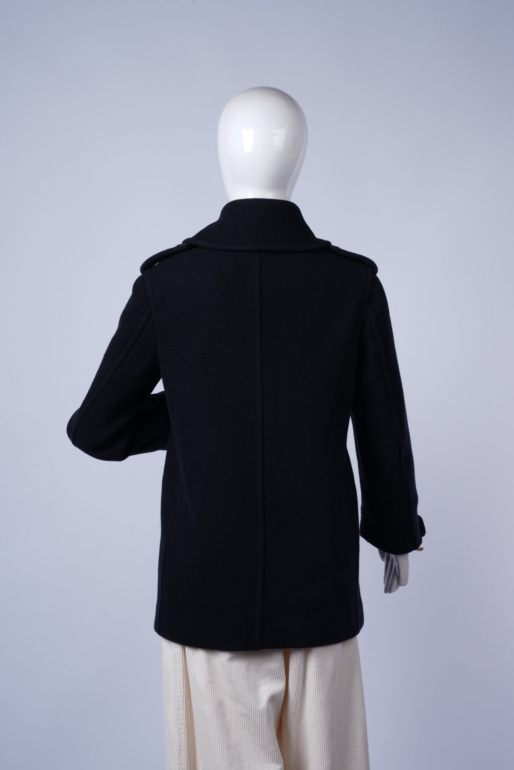 Elegant winter coat featuring gold-button details and warm structured design.