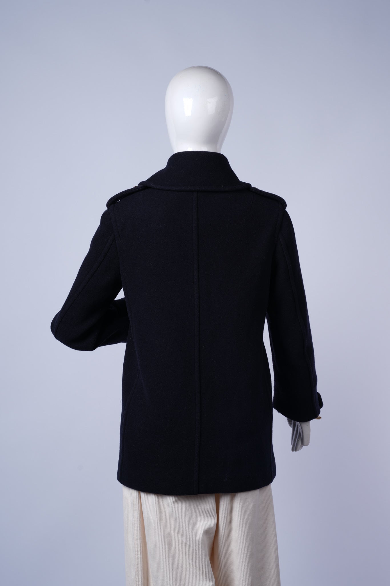Elegant winter coat featuring gold-button details and warm structured design.