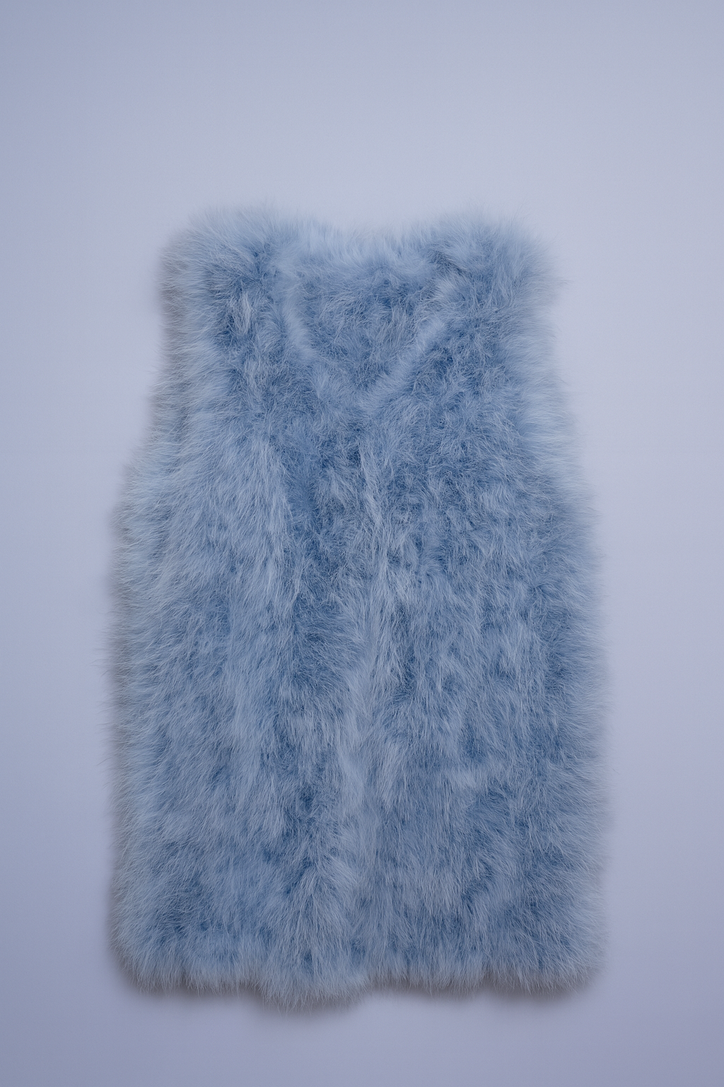Light blue faux-fur vest with plush, shaggy texture for stylish layering.