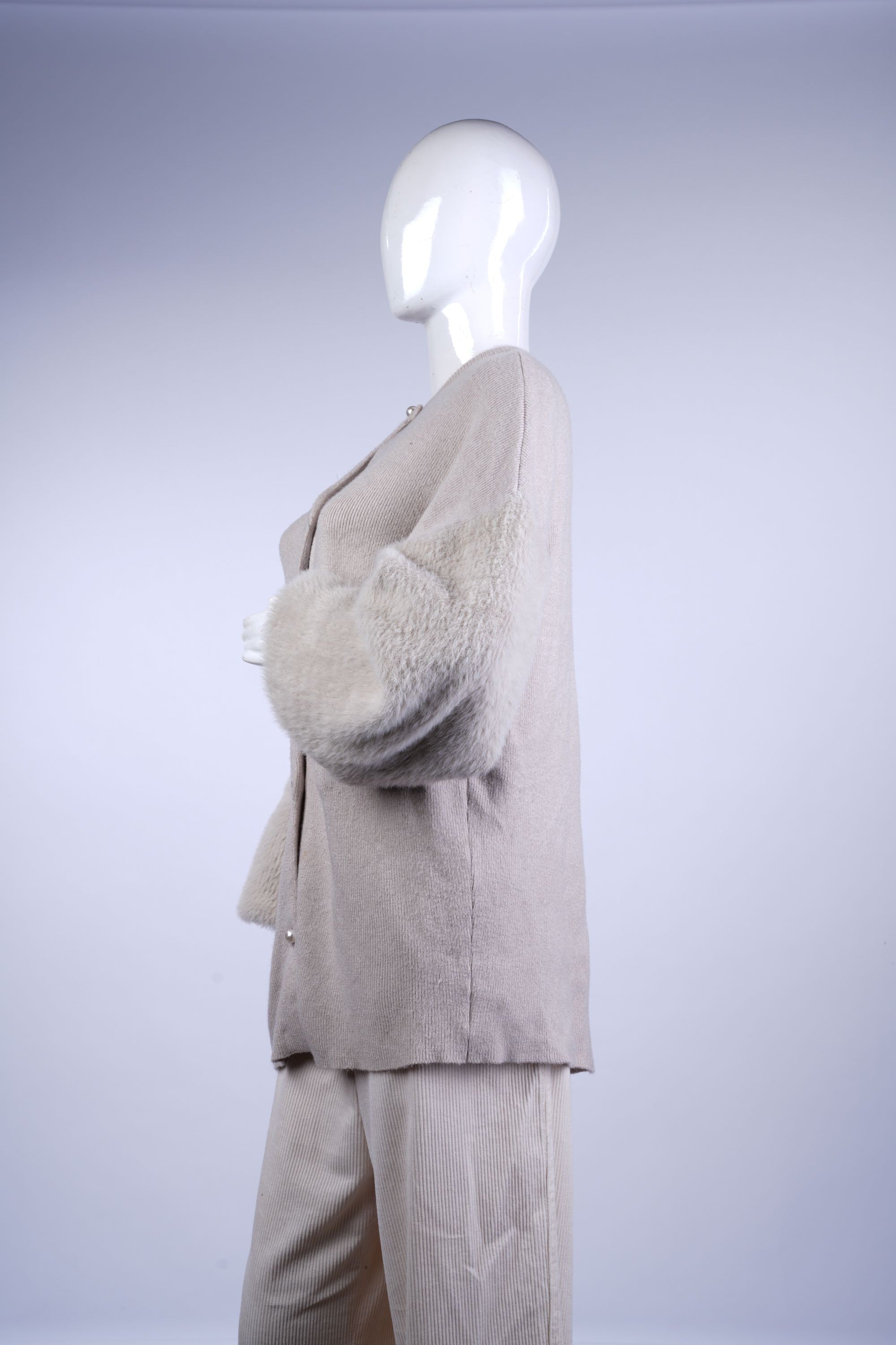 Elegant knit top with voluminous sleeves and relaxed fit for layered outfits.