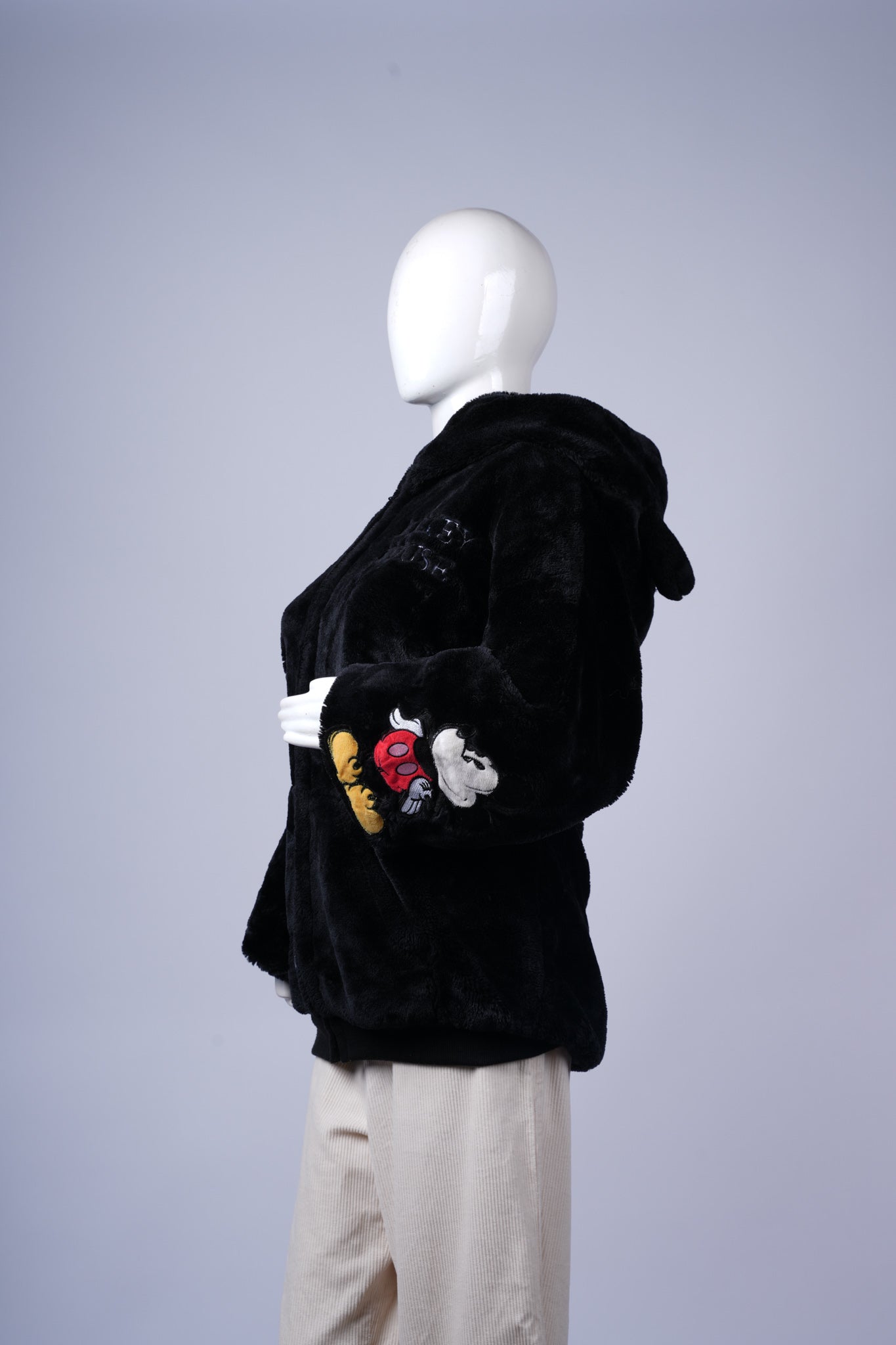 Casual hooded jacket in black featuring plush texture and fun embroidered design.