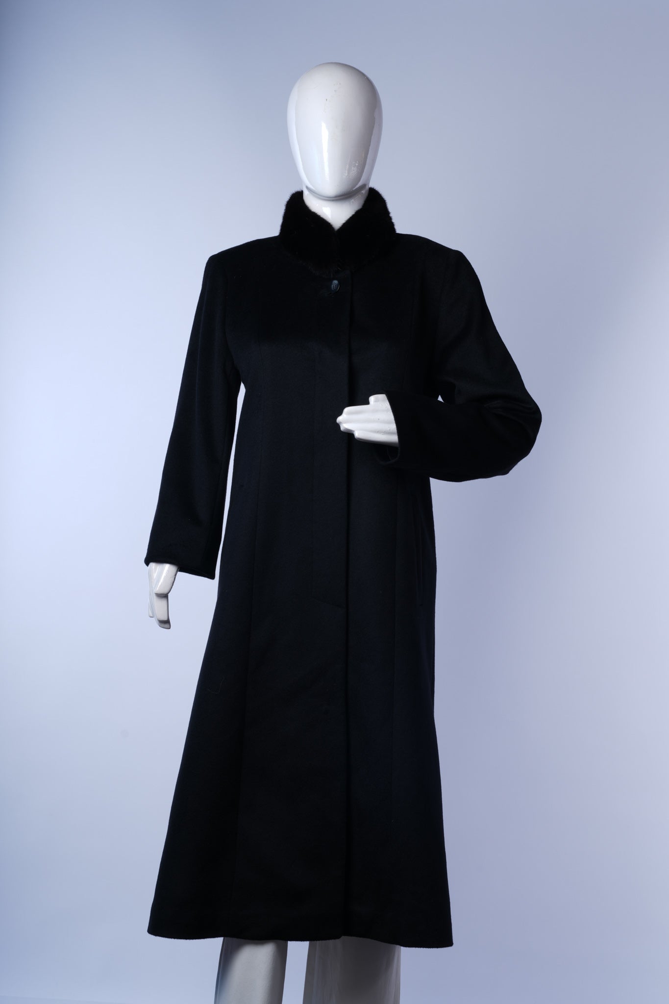 Elegant black long coat for women with luxurious fur-trimmed collar and waist belt.