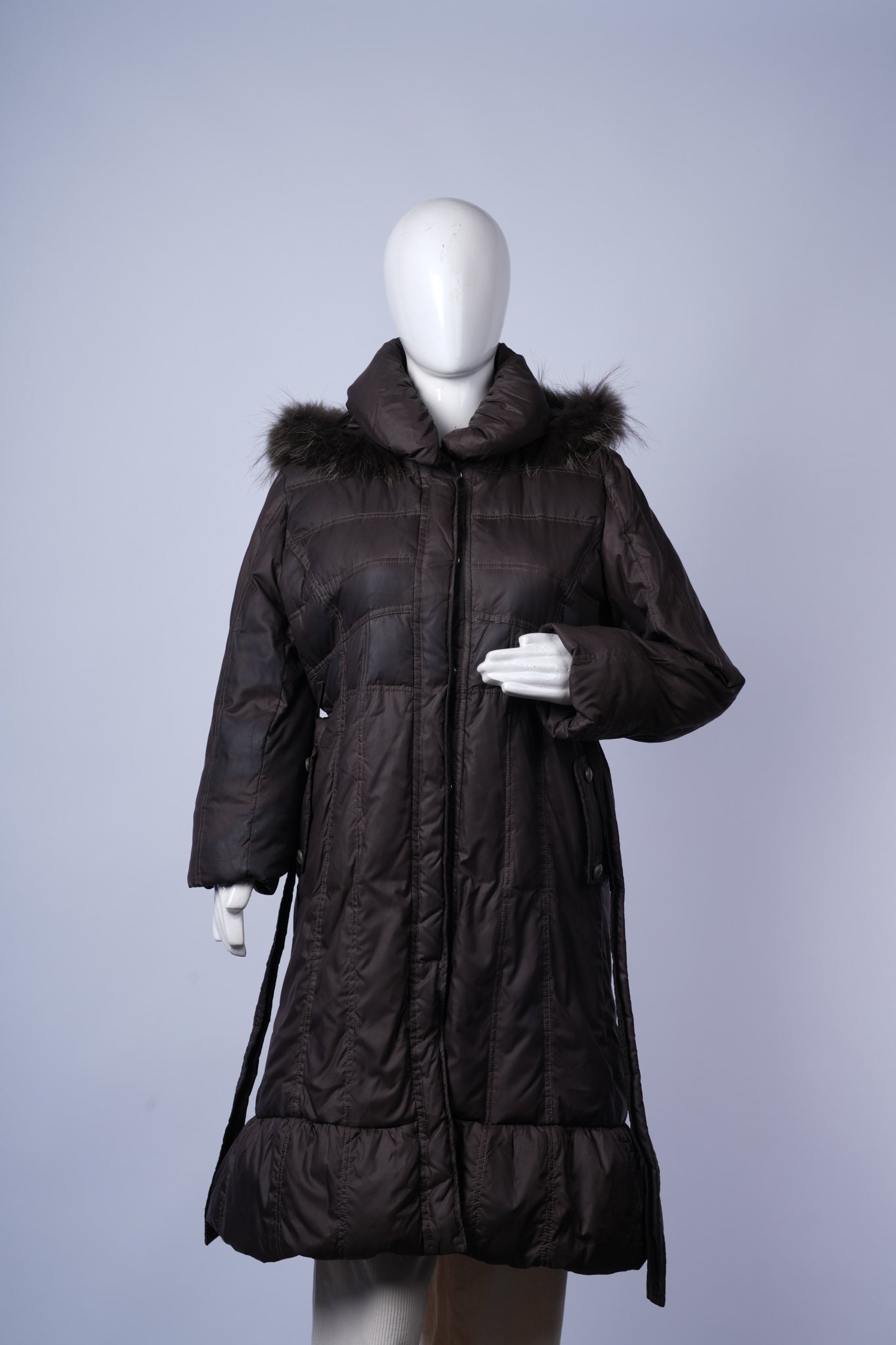 Cozy women's puffer jacket featuring long quilted design and adjustable belt.