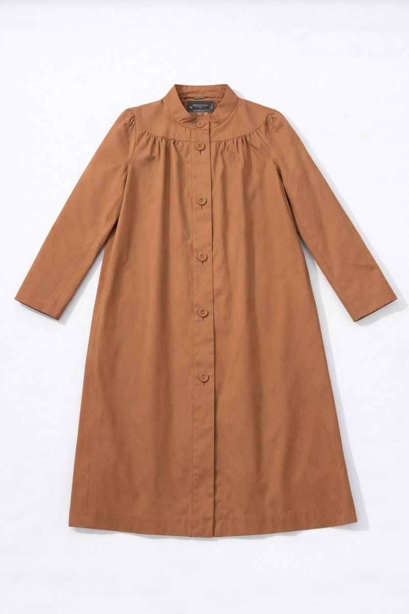 Knee-length single-breasted coat with banded collar, long sleeves, and A-line silhouette